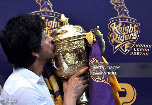 Indian Bollywood actor and Indian Premier League franchise Kolkata Knight Rider’s co-owner Shah Rukh Khan kisses the IPL trophy during a press...