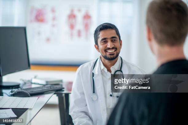 médico masculino con un paciente - she males fotografías e imágenes de stock