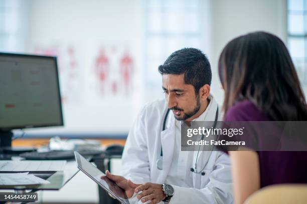 male doctor with a female patient - hispanic medical exam stock pictures, royalty-free photos & images