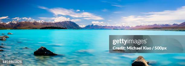 panoramic view of sea and mountains against blue sky,lake pukaki,canterbury,new zealand - lake pukaki stock pictures, royalty-free photos & images