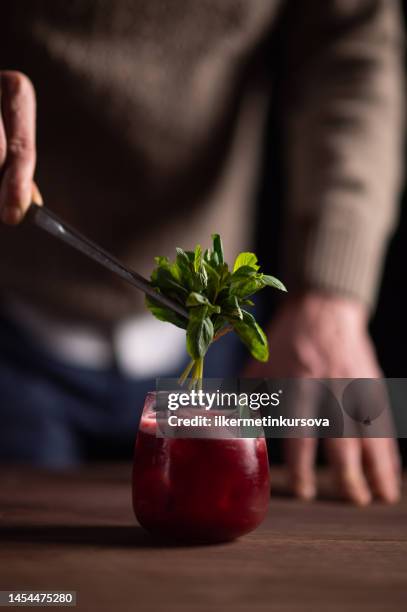 ein barkeeper trinkt ein glas negroni - cocktail gin stock-fotos und bilder