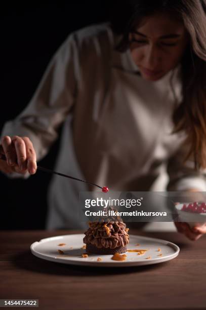 eine köchin dekoriert eine tanienartige kastanientarte - woman making cake stock-fotos und bilder