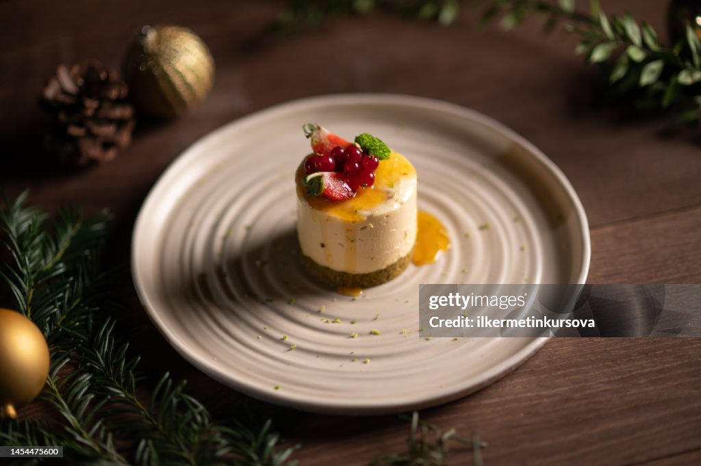 A plate of a fruitcake with strawberry and cranberries