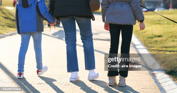 half-length back photo of the mother with her two daughters walking her dog through the recreation area - girl with legs open stock pictures, royalty-free photos & images