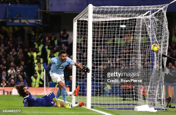 Riyad Mahrez of Manchester City scores the team's first goal whilst under pressure from Marc Cucurella of Chelsea during the Premier League match...