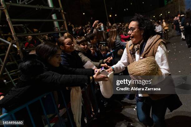 Children take candy during the Three Kings Parade in Madrid on January 05, 2023 in Madrid, Spain.