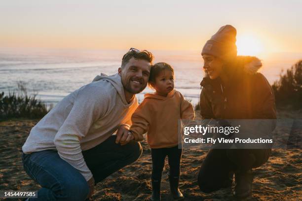 happy family enjoying coastal sunset - healthy lifestyle winter stock pictures, royalty-free photos & images