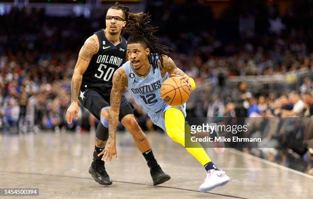 Ja Morant of the Memphis Grizzlies drives on Cole Anthony of the Orlando Magic during a game at Amway Center on January 05, 2023 in Orlando, Florida....
