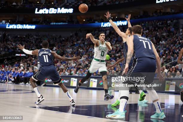 Jayson Tatum of the Boston Celtics passes the ball against Dwight Powell of the Dallas Mavericks and Tim Hardaway Jr. #11 of the Dallas Mavericksin...