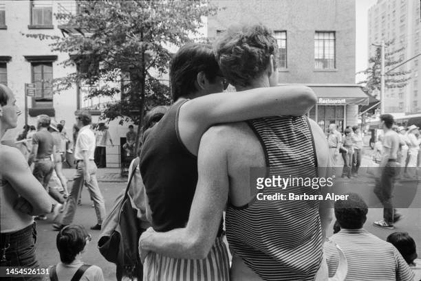 View, from behind, of two participants with their arms around one another during the Lesbian and Gay Pride March , New York, New York, June 26, 1983.