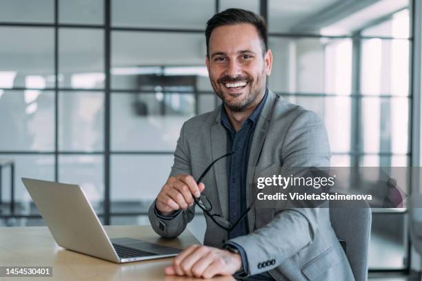 homme d’affaires prospère dans un bureau moderne travaillant sur ordinateur portable. - conseiller-bancaire photos et images de collection