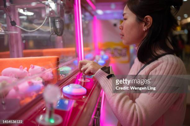 leisure and entertainment, playing claw machine - claw machine stock pictures, royalty-free photos & images