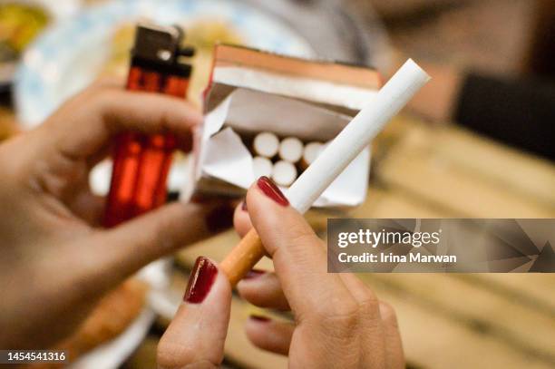 woman smoking cigarette - paquete de cigarrillos fotografías e imágenes de stock