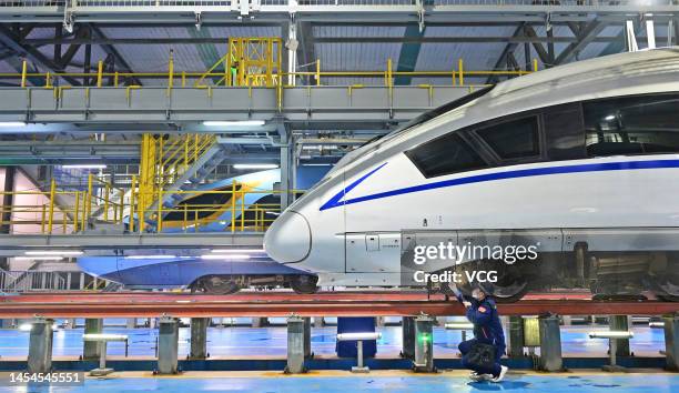 Technician examines a bullet train at a maintenance base in preparation for the Spring Festival travel rush on January 6, 2023 in Zhengzhou, Henan...
