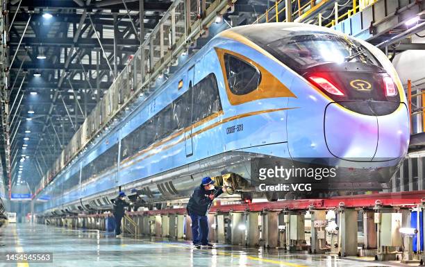 Technicians examine a bullet train at a maintenance base in preparation for the Spring Festival travel rush on January 6, 2023 in Zhengzhou, Henan...