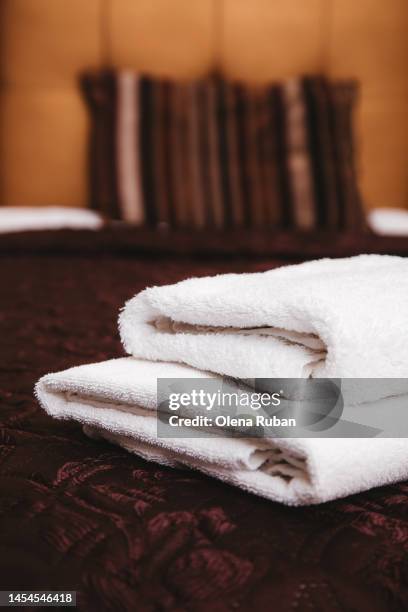 white towels on burgundy coverlet - confort at hotel bedroom ストックフォトと画像