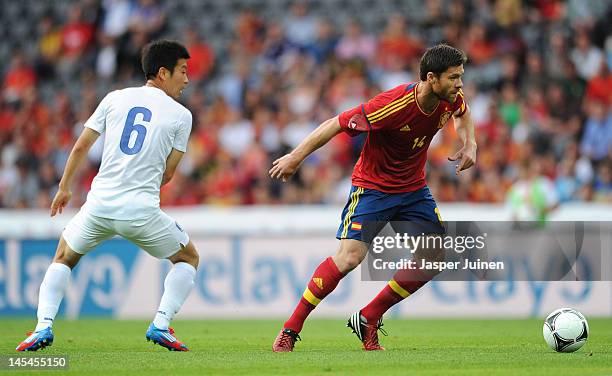 Xabi Alonso of Spain duels for the ball with Do Heon Kim of Korea Republic during the international friendly match between Spain and Korea Republic...