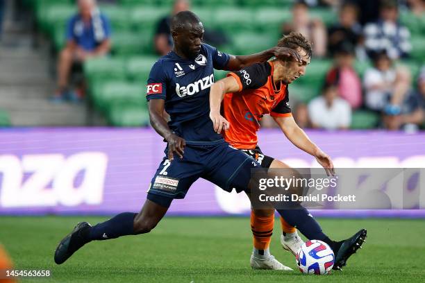 Jason Geria of the Victory steals the ball from Carlo Armiento of the Roar during the round 11 A-League Men's match between Melbourne Victory and...