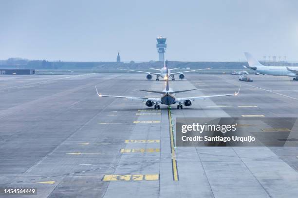 airplanes heading to the airport runway at brussels airport - airplane runway stockfoto's en -beelden