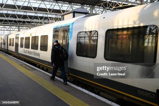 Man walks towards a train at Waterloo station as disruption to services begins during the morning rush hour, due to ongoing strike action on January...