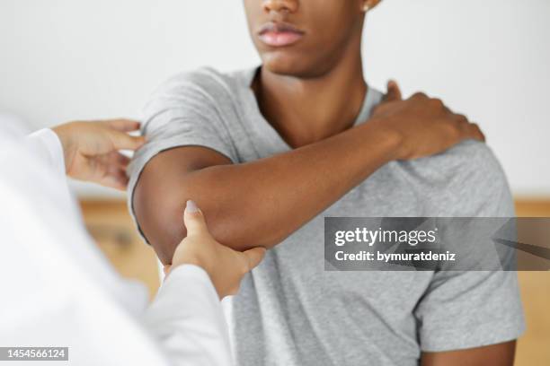 doctor checking patient with elbow to determine the cause of illness - arm pain stock pictures, royalty-free photos & images