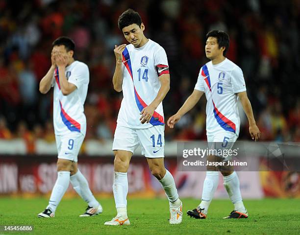 Jung Soo Lee of Korea Republic trudges off the pitch with his teammates Joo Ho Park and Chi Woo Kim at the end of the international friendly match...