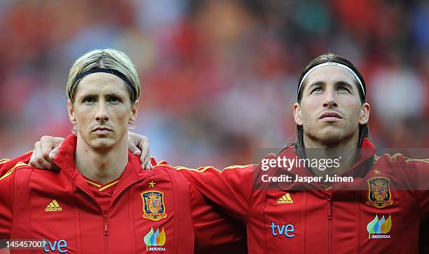 Fernando Torres of Spain stands with his teammate Sergio Ramos as they listen to their countries national anthem during the international friendly...