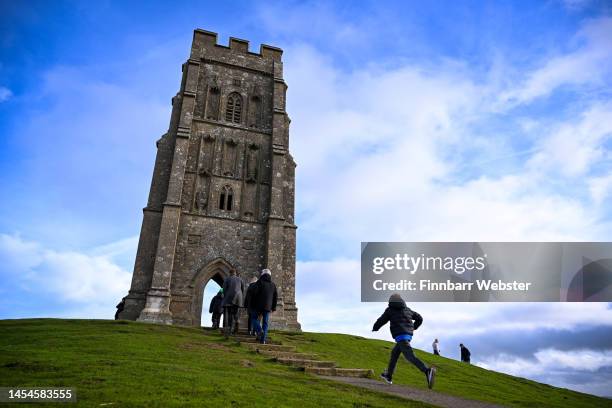 People enjoy the weather at St. Michael's Tower at the top of Glastonbury Tor on January 06, 2023 in Glastonbury, England.