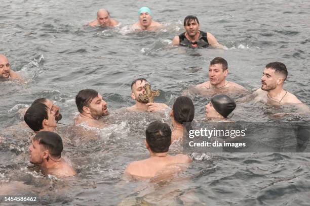 Greek Orthodox faithful retrieve a wooden cross from the waters of the Golden Horn during the blessing of the water ceremony, as part of Epiphany day...