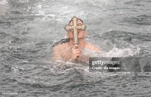 Greek Orthodox faithful retrieve a wooden cross from the waters of the Golden Horn during the blessing of the water ceremony, as part of Epiphany day...