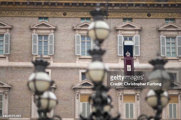 Pope Francis delivers his Angelus blessing from the window of his private studio to pilgrims gathered in Saint Peter's Square during the Feast of the...