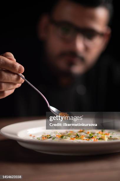 chef putting caviar with a spoon on lasagna - serving dish imagens e fotografias de stock