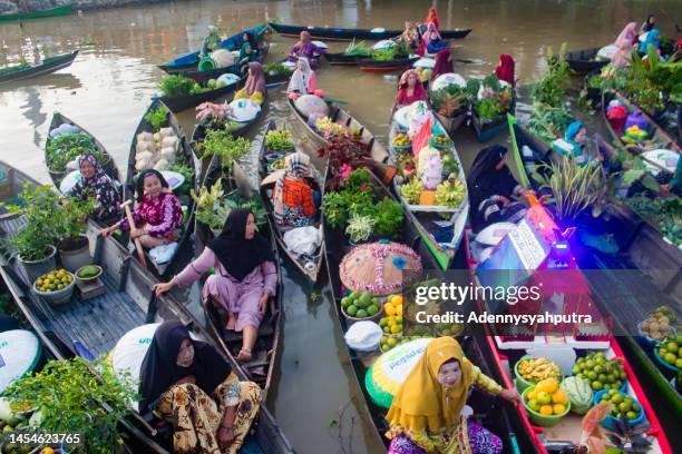 acquisto e vendita al mercato galleggiante lok baintan a banjarmasin, indonesia - indonesian ethnicity foto e immagini stock