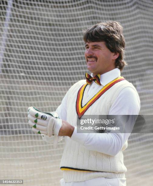 England batsman Allan Lamb pictured in a MCC bow tie as he puts on his batting gloves during nets ahead of the 2nd Test Match on December 11th, 1984...