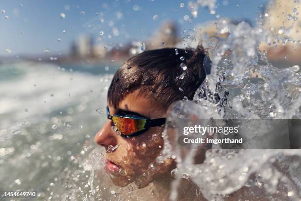 teenage boy playing in the summer sea - droplet sea summer stock pictures, royalty-free photos & images