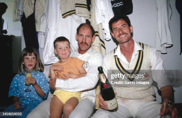 Notts players Clive Rice and Richard Hadlee celebrate in the dressing room with children after Notts had beaten Glamorgan to win the 1987 County...