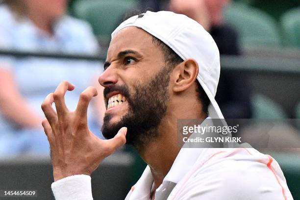 France's Laurent Lokoli reacts as he plays Norway's Casper Ruud during their men's singles tennis match on the first day of the 2023 Wimbledon...