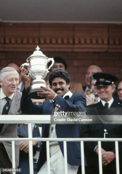 India all rounder Kapil Dev holds aloft the trophy on the balcony after the 1983 Cricket World Cup final Match between India and West Indies at Lords...
