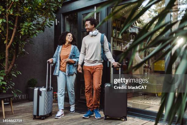 afroamerikanische touristen mit koffern vor der gemieteten wohnung - suitcase couple stock-fotos und bilder