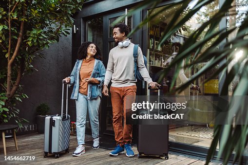 African-American tourists with suitcases in front of the rented apartment African-American tourists with suitcases in front of the rented apartment