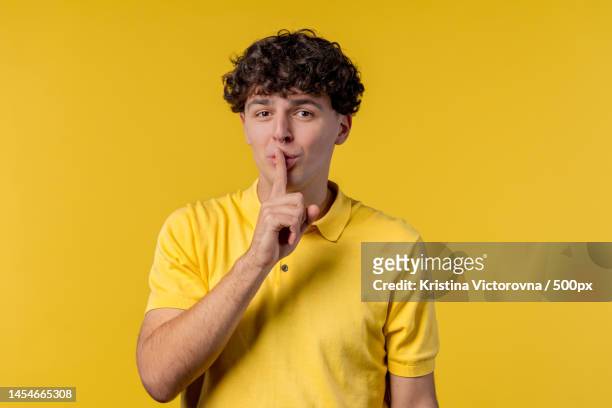 handsome man with gesture of shhh,secret,silence,conspiracy,gossip - shhh finger stock pictures, royalty-free photos & images