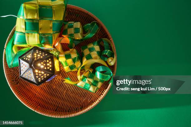 top view of arabic lantrn and ribbon ketupat against green background,malaysia - ketupat stock pictures, royalty-free photos & images