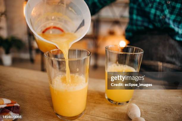 gießen sie einen frischen und gesunden orangensaft ein! - orangensaft stock-fotos und bilder