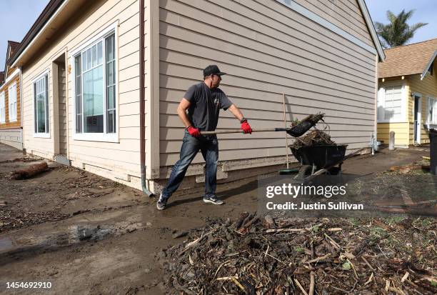 Matt Arthur cleans up debris after large waves surged into the town following a massive storm that hit the area on January 06, 2023 in Capitola,...