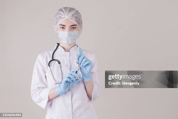 arzt in handschuhen mit spritze - anesthesia mask stock-fotos und bilder