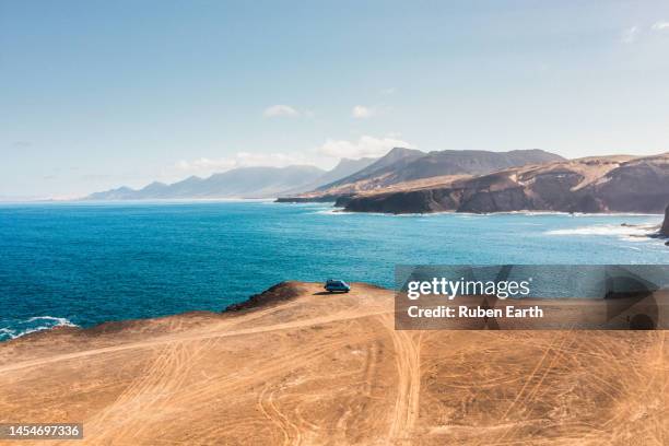 camper van on a dirt road on the coast of fuerteventura - campingplatz stock-fotos und bilder