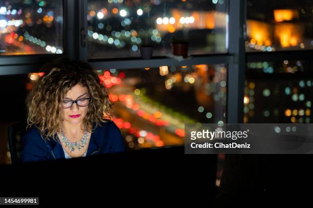 image of female clerk working evening shift in office - overheidsberoep stockfoto's en -beelden