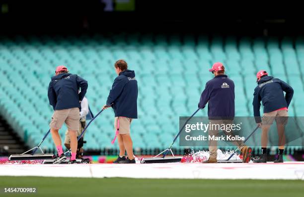 Ground staff work to dry the field during day four of the Third Test match in the series between Australia and South Africa at Sydney Cricket Ground...