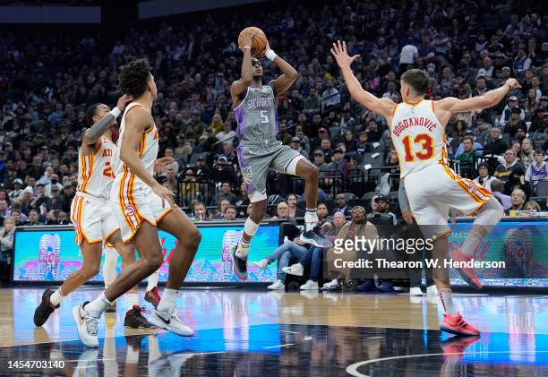 De'Aaron Fox of the Sacramento Kings shoots over Bogdan Bogdanovic of the Atlanta Hawks during the first quarter of an NBA basketball game at Golden...