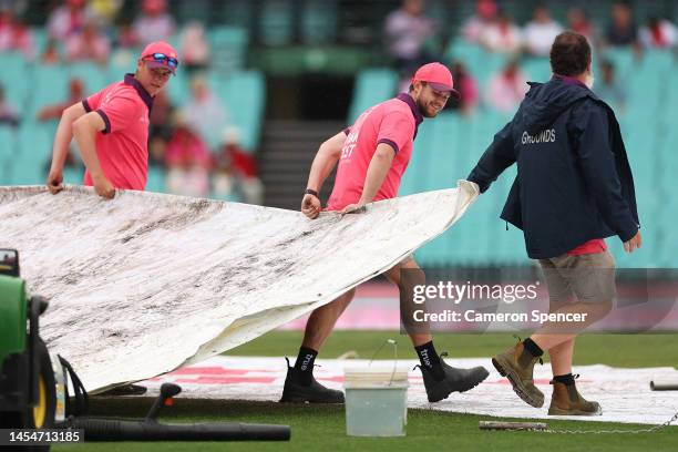 Ground staff move the rain covers during day four of the Third Test match in the series between Australia and South Africa at Sydney Cricket Ground...
